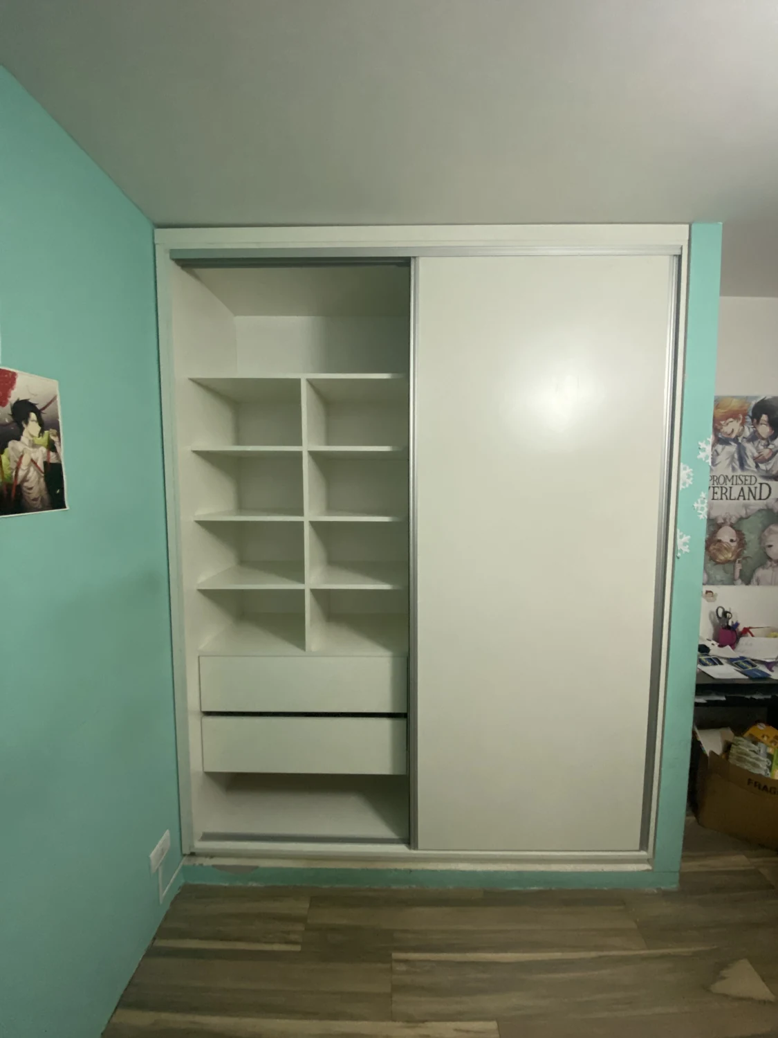 Placard blanco instalado, con estantes y cajones detrás de puertas corredizas